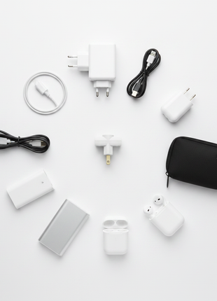 Adaptador de enchufe universal – flat lay con cargador de celular y laptop – solución eléctrica para viajes

