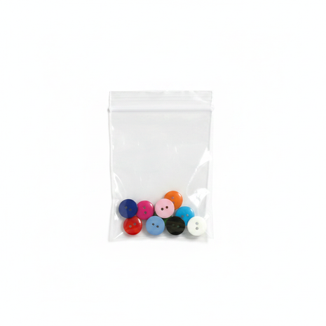 Botones de colores en bolsa transparente sobre fondo blanco