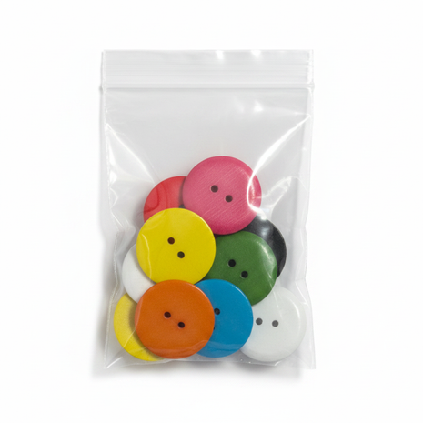 Botones grandes de colores en bolsa transparente sobre fondo blanco