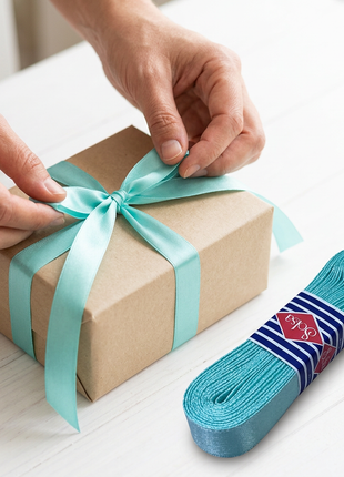 Cinta satinada turquesa decorando un regalo