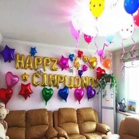 Globo foil dorado Feliz Cumpleaños decorando sala de cumpleaños con globos corazón y estrella multicolor