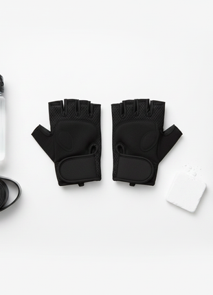 Guantes deportivos sin dedos negros vista cenital con accesorios de gym, equipamiento fitness completo Perú

