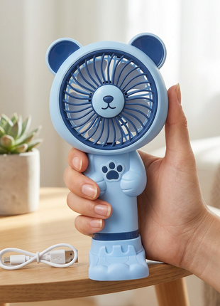 Mini ventilador celeste sostenido en una mano