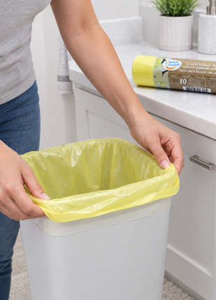 Persona colocando una bolsa en un tacho de baño
