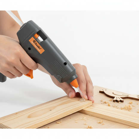 Persona usando pistola de silicona Asaki ASK-17202 40W