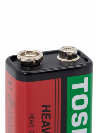 Detalle pila 9V Toshiba – conector snap metálico y etiqueta roja y verde – batería alcalina de alta calidad

