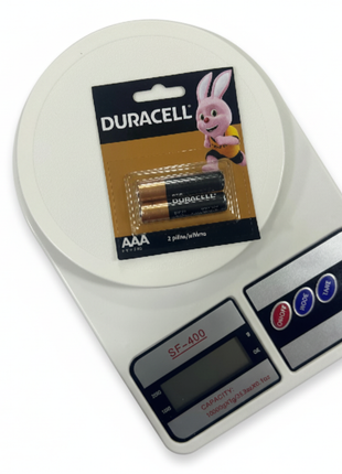 Pilas Duracell AAA y Balanza SF-400 fondo blanco