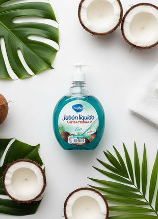 Tópico jabón líquido antibacterial coco 1L – flat lay con coco natural y hojas tropicales – aroma fresco

