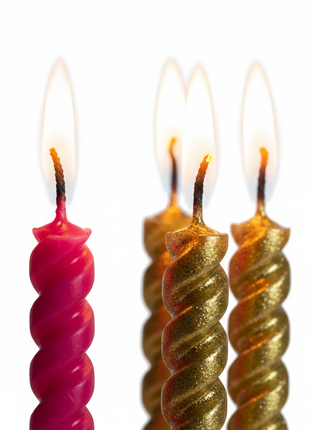 Macro velas espiral rosado y dorado encendidas – detalle textura brillante para tortas y mesas dulces

